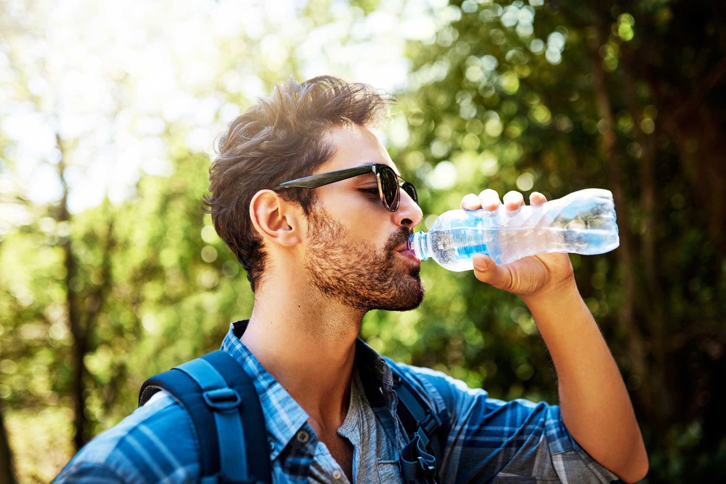 Пить. Мужчина пьет воду. Человек с бутылкой воды. Парень пьет воду. Парень с бутылкой воды.